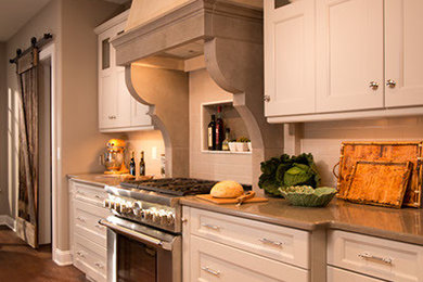 Open concept kitchen - large traditional galley dark wood floor open concept kitchen idea in New York with recessed-panel cabinets, an island, a farmhouse sink, gray cabinets, quartz countertops, gray backsplash, subway tile backsplash and stainless steel appliances