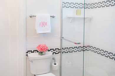 Small traditional kids bathroom in Austin with furniture-like cabinets, black cabinets, solid surface benchtops, white tile, subway tile, a two-piece toilet, a console sink, white walls and porcelain floors.