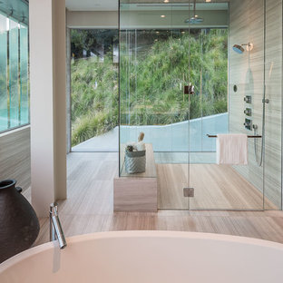 ロサンゼルスの大きいモダンスタイルのおしゃれなマスターバスルーム (フラットパネル扉のキャビネット、中間色木目調キャビネット、置き型浴槽、洗い場付きシャワー、ベージュの壁、クッションフロア、ベッセル式洗面器、クオーツストーンの洗面台) の写真
