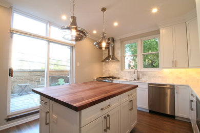 Enclosed kitchen - mid-sized contemporary u-shaped light wood floor and gray floor enclosed kitchen idea in Chicago with an undermount sink, shaker cabinets, white cabinets, wood countertops, gray backsplash, subway tile backsplash, stainless steel appliances and an island