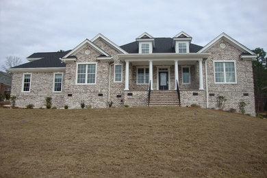 Mid-sized traditional white two-story brick exterior home idea in Other