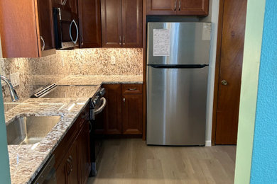 Mid-sized trendy l-shaped vinyl floor eat-in kitchen photo in Cleveland with a single-bowl sink, granite countertops, granite backsplash and stainless steel appliances