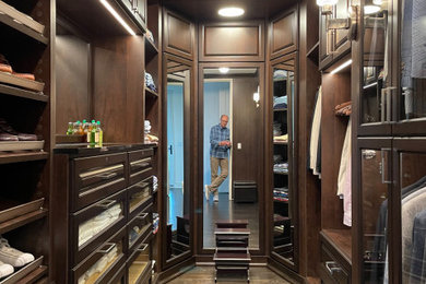 Modelo de armario vestidor de hombre tradicional de tamaño medio con armarios con paneles con relieve y puertas de armario de madera en tonos medios