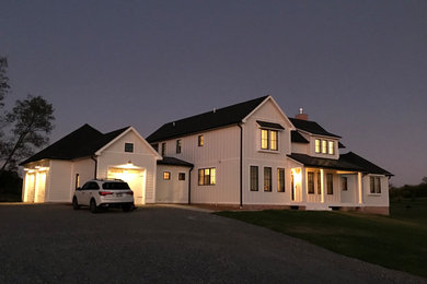 Inspiration for a large cottage white two-story wood house exterior remodel in DC Metro with a hip roof and a mixed material roof