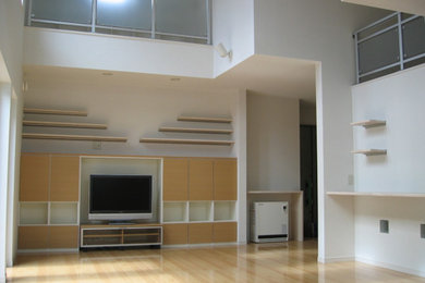 This is an example of a large modern living room in Other with white walls, plywood floors, no fireplace and a freestanding tv.