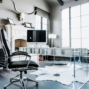 Large modern study in Phoenix with grey walls, dark hardwood flooring, a standard fireplace, a stone fireplace surround, a freestanding desk and black floors.