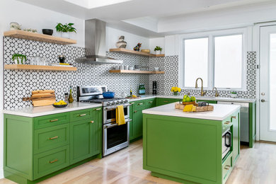 Cette photo montre une cuisine parallèle tendance fermée et de taille moyenne avec un évier encastré, un placard à porte shaker, des portes de placards vertess, un plan de travail en quartz modifié, une crédence multicolore, une crédence en céramique, un électroménager en acier inoxydable, îlot, un plan de travail blanc, parquet clair, un sol marron et un plafond décaissé.