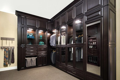 Photo of a large traditional gender-neutral walk-in wardrobe in San Francisco with raised-panel cabinets, dark wood cabinets, carpet and multi-coloured floor.