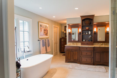 This is an example of a large traditional master bathroom in Louisville with raised-panel cabinets, dark wood cabinets, a freestanding tub, grey walls, granite benchtops and an undermount sink.