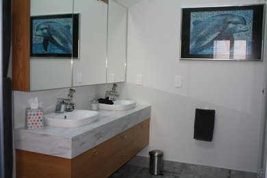 クライストチャーチにあるモダンスタイルのおしゃれな浴室 (白いタイル、磁器タイルの床、オーバーカウンターシンク、グレーの床) の写真