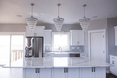 Inspiration for a large contemporary l-shaped dark wood floor and brown floor open concept kitchen remodel in Other with a farmhouse sink, white cabinets, stainless steel appliances, an island, shaker cabinets, quartz countertops, multicolored backsplash, matchstick tile backsplash and white countertops