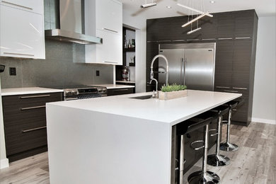 Mid-sized contemporary galley eat-in kitchen in Calgary with a single-bowl sink, flat-panel cabinets, white cabinets, quartzite benchtops, metallic splashback, ceramic splashback, stainless steel appliances, vinyl floors, with island and grey floor.