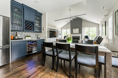 Example of a mid-sized transitional medium tone wood floor open concept kitchen design in Chicago with a drop-in sink, shaker cabinets, quartz countertops, multicolored backsplash, mosaic tile backsplash, stainless steel appliances, an island and white countertops