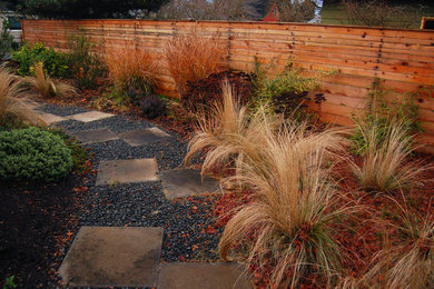 This is an example of a mid-sized contemporary front yard full sun xeriscape in Portland with concrete pavers.