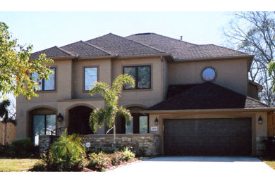 Large trendy brown two-story stucco exterior home photo in Houston