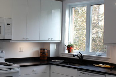 Inspiration for a mid-sized modern l-shaped porcelain tile and gray floor enclosed kitchen remodel in Other with flat-panel cabinets, white cabinets, solid surface countertops and white appliances