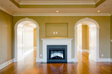 Large elegant open concept medium tone wood floor family room photo in Louisville with green walls, a standard fireplace, a stone fireplace and a wall-mounted tv