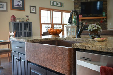 Large transitional l-shaped medium tone wood floor kitchen photo in Other with a farmhouse sink, raised-panel cabinets, light wood cabinets, granite countertops, stainless steel appliances and an island