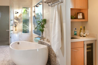 This is an example of a large contemporary master bathroom in San Diego with flat-panel cabinets, medium wood cabinets, a freestanding tub, an open shower, pebble tile and beige walls.