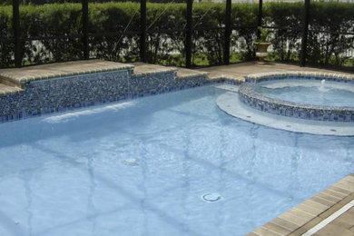 Example of a mid-sized backyard stamped concrete and rectangular natural hot tub design in Jacksonville