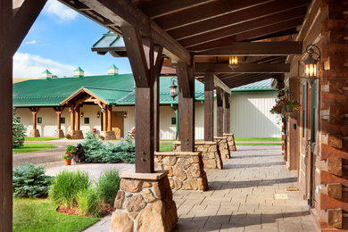 Inspiration for a large rustic front yard concrete paver patio remodel in Denver with a roof extension