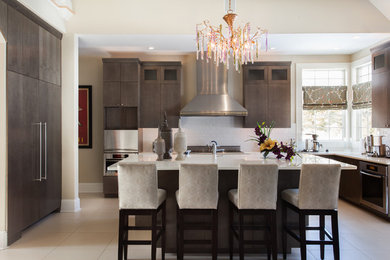 Transitional kitchen photo in Philadelphia with flat-panel cabinets, brown cabinets, white backsplash, subway tile backsplash, paneled appliances and an island