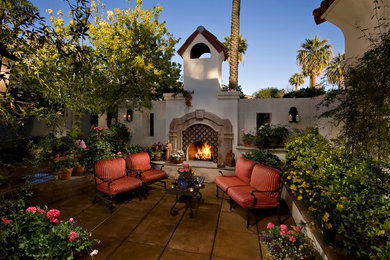 Photo of a mid-sized mediterranean backyard patio in Phoenix with a fire feature, concrete pavers and no cover.