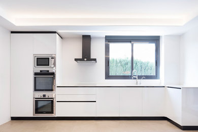 Diseño de cocinas en L actual de tamaño medio cerrada sin isla con fregadero encastrado, puertas de armario blancas y encimeras blancas