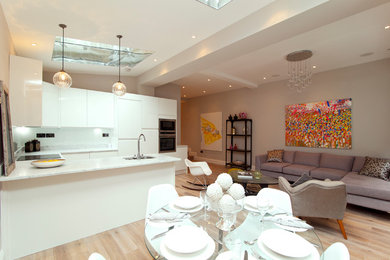 Inspiration for a mid-sized contemporary living room in London with grey walls, light hardwood floors and no fireplace.