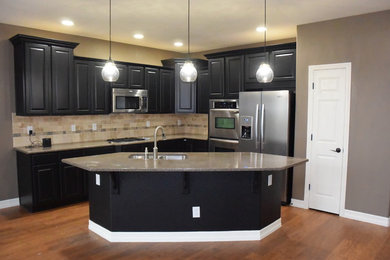 Photo of a mid-sized contemporary l-shaped eat-in kitchen in Denver with black cabinets and with island.