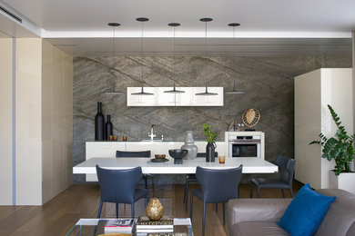 На фото: кухня-столовая среднего размера в современном стиле с серыми стенами, паркетным полом среднего тона, коричневым полом, многоуровневым потолком и панелями на части стены без камина с