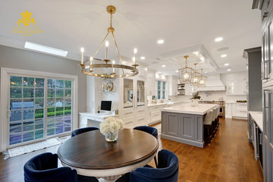 Eat-in kitchen - traditional coffered ceiling eat-in kitchen idea in Other with a farmhouse sink, shaker cabinets, white cabinets, marble countertops, white backsplash, subway tile backsplash, paneled appliances, an island and multicolored countertops