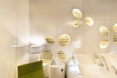Modelo de habitación de invitados actual de tamaño medio con paredes blancas y suelo de madera en tonos medios