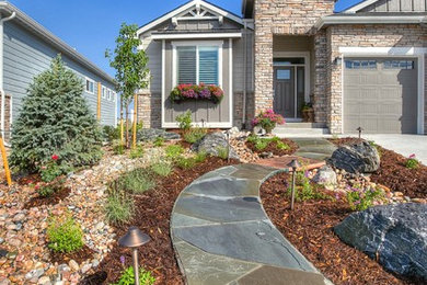 Inspiration for a mid-sized transitional front yard full sun xeriscape in Denver with natural stone pavers.