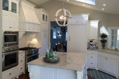 Kitchen - large traditional u-shaped medium tone wood floor and brown floor kitchen idea in Los Angeles with an undermount sink, raised-panel cabinets, white cabinets, white backsplash, subway tile backsplash, stainless steel appliances and an island