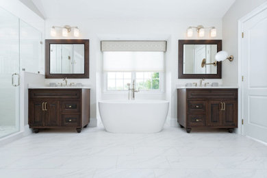 Inspiration for a large transitional master gray tile and porcelain tile porcelain tile, white floor, double-sink, vaulted ceiling and wallpaper bathroom remodel in Philadelphia with shaker cabinets, dark wood cabinets, a two-piece toilet, gray walls, an undermount sink, quartz countertops, a hinged shower door, white countertops and a freestanding vanity