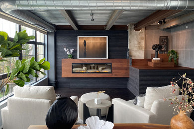 ボルチモアにある高級な中くらいなコンテンポラリースタイルのおしゃれなLDK (黒い壁、吊り下げ式暖炉、木材の暖炉まわり、茶色い床、表し梁、板張り壁、濃色無垢フローリング) の写真