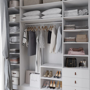 Photo of a small scandinavian gender-neutral walk-in wardrobe in Other with white cabinets, medium hardwood floors, brown floor and open cabinets.