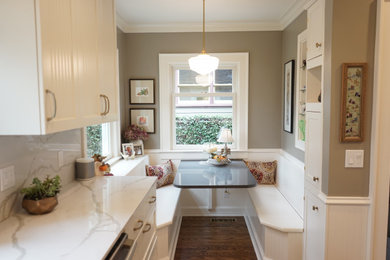 Inspiration for a mid-sized transitional l-shaped dark wood floor and brown floor enclosed kitchen remodel in Portland with shaker cabinets, white cabinets, quartz countertops, white backsplash, stone slab backsplash, stainless steel appliances, an island, white countertops and an undermount sink