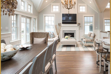 Example of a large beach style medium tone wood floor and brown floor great room design in Other with gray walls, a standard fireplace and a stone fireplace