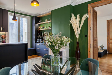 Aménagement d'une salle de séjour classique de taille moyenne et ouverte avec un mur vert, parquet clair, une cheminée standard et un manteau de cheminée en pierre.