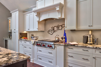 Inspiration for a large transitional l-shaped dark wood floor, brown floor and vaulted ceiling eat-in kitchen remodel in Charlotte with an undermount sink, shaker cabinets, white cabinets, granite countertops, gray backsplash, stainless steel appliances, an island and white countertops
