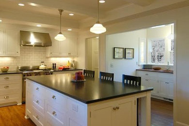 Open concept kitchen - traditional medium tone wood floor open concept kitchen idea in Minneapolis with shaker cabinets, white cabinets, white backsplash, subway tile backsplash, stainless steel appliances and an island