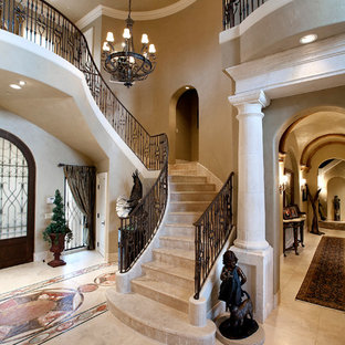 Mediterranean curved staircase in Dallas with travertine treads and travertine risers.