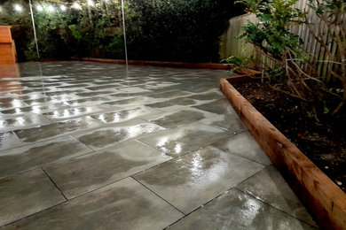 Large contemporary back patio in Hampshire with natural stone paving.