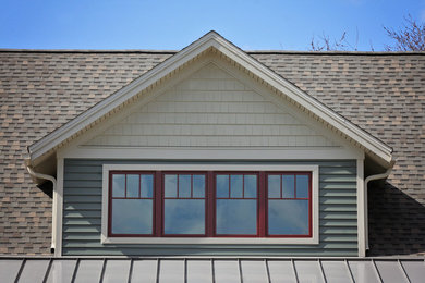 Example of an arts and crafts green mixed siding exterior home design in Philadelphia with a shingle roof