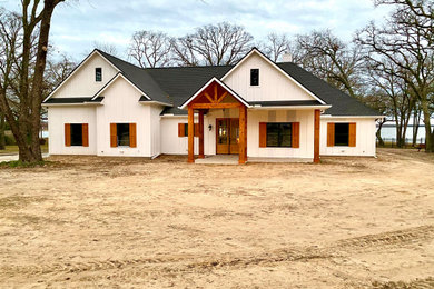 Farmhouse white one-story mixed siding and board and batten gable roof idea in Dallas with a shingle roof and a black roof