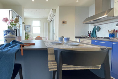 Idee per una cucina minimal con lavello da incasso, ante turchesi, paraspruzzi bianco, paraspruzzi con piastrelle a mosaico, elettrodomestici in acciaio inossidabile, pavimento in gres porcellanato, pavimento beige, top grigio e top in quarzo composito