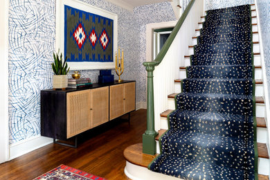 Inspiration for an eclectic medium tone wood floor entryway remodel in Atlanta with multicolored walls and a black front door