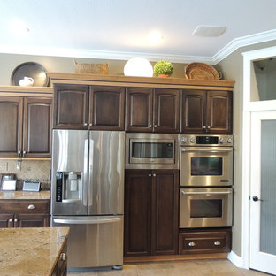Large traditional kitchen pantry photos - Large elegant u-shaped ceramic floor kitchen pantry photo in Indianapolis with a drop-in sink, raised-panel cabinets, dark wood cabinets, granite countertops, black backsplash, ceramic backsplash, stainless steel appliances and an island